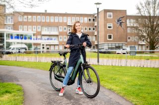 Vrouw op e-bike bij zorginstelling Groningen